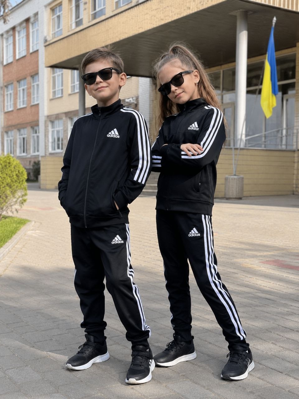 Хлопчик і дівчинка в чорних дитячих костюмах Adidas
